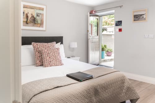 Modern double bedroom at Madeline's Accommodation in Wicklow with mountain view, featuring patterned cushions and glass door