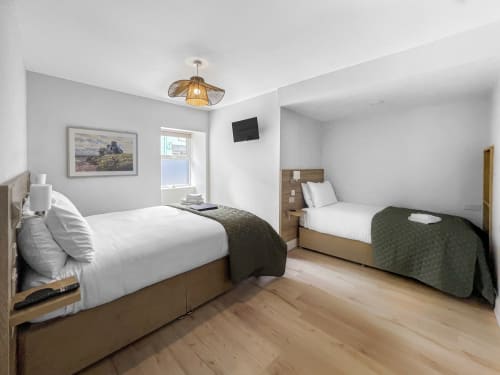 Twin bedroom at Madeline's Accommodation in Wicklow with two beds, wooden flooring, and modern amenities
