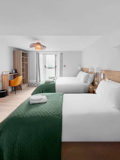 Twin Room with Private Bathroom at Madeline's Accommodation in Wicklow featuring two beds with green bedding and desk