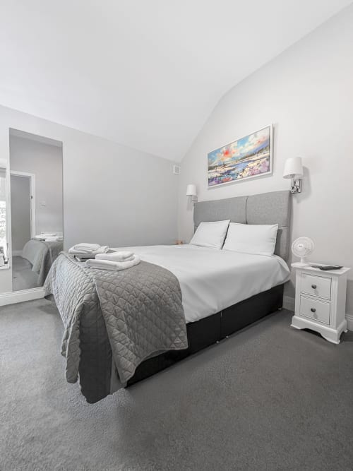 Madeline's Accommodation small double room in Wicklow with gray headboard, white linens, and ensuite bathroom