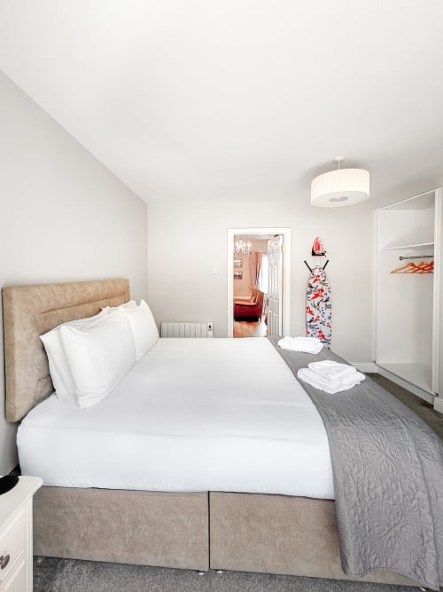 Modern King Studio bedroom at Madeline's Accommodation, Wicklow with beige upholstered bed, white linens, and bright