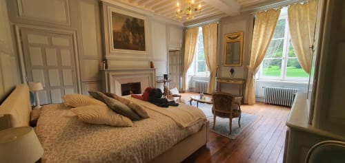 Suite élégante du Manoir de Saint-Ouen avec cheminée, rideaux dorés et vue sur les jardins entretenus de Sideville