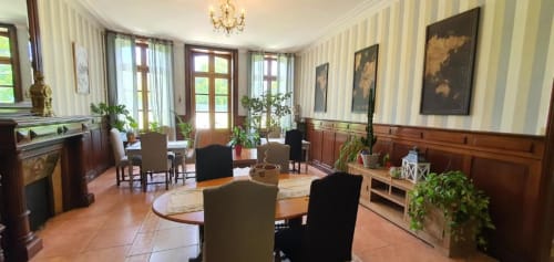 Élégante salle à manger du Manoir de Saint-Ouen avec mobilier d'époque, carrelage en terre cuite et papier peint rayé à Sideville.