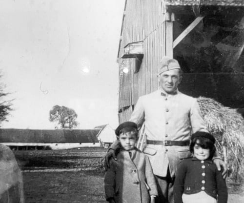 Homme et deux enfants en tenue d'époque devant une ferme rurale française avec grange, Saint-Hilaire-sur-Puiseaux