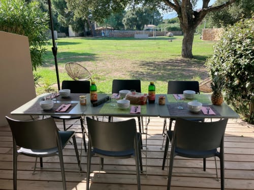 Aménagement de repas en plein air à l'hôtel Alma Rossa à Lecci avec table, chaises et vues sur la campagne