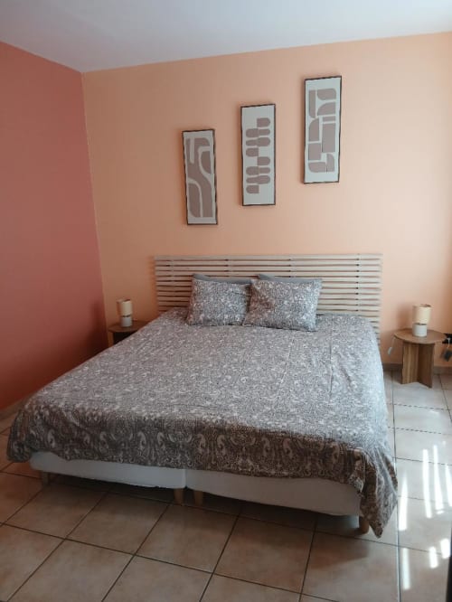 Bedroom at Les Petits Nids De Nina hotel in Fosses-la-Ville with queen bed, peach walls, and city view