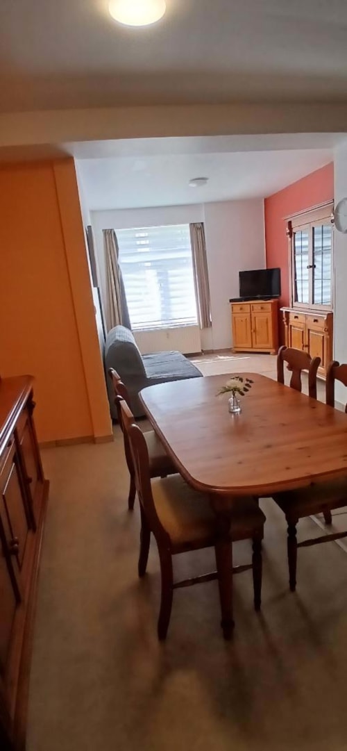 Spacious apartment dining area with wooden table and chairs at Les Petits Nids De Nina hotel in Fosses-la-Ville, Belgium