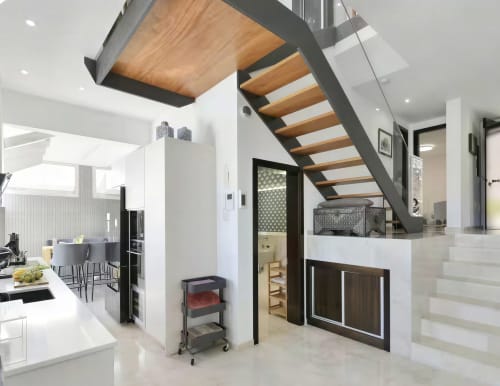 Modern villa interior at Home Stay Gran Canaria with open-plan kitchen, wooden staircase, and contemporary design elements in