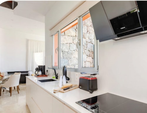 Modern kitchen in Sweet Green 21 villa at Home Stay Gran Canaria with white counters, stone views, and appliances