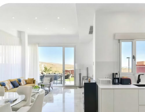 Modern villa interior with kitchen, living area, terrace views of pool and mountains in Gran Canaria