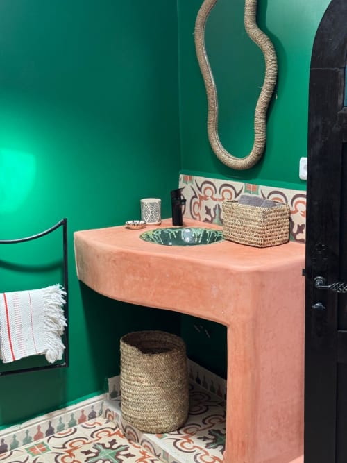Salle de bain style marocain à l'hôtel Eucalyptus Ethnic avec lavabo en terre cuite, murs verts, détails de corde tressée et éléments décoratifs