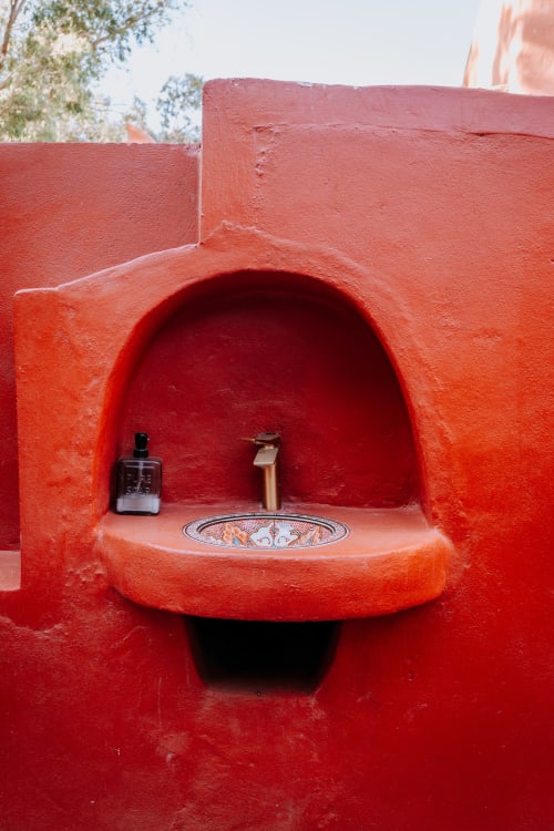 Niche cintrée rouge vif avec carreaux décorés à l'hôtel Eucalyptus Ethnic à Essaouira, Maroc