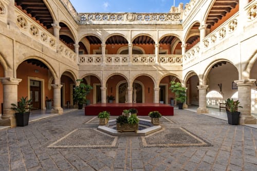Patio del Hostal La Moyareja en Rota con columnata de arcos, azulejos decorativos y macetas con plantas