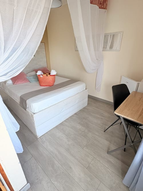 Spacieuse chambre double de l'Hôtel le soleil couchant avec lit à baldaquin, bureau de travail et équipements modernes à Saint-Pierre, Réunion