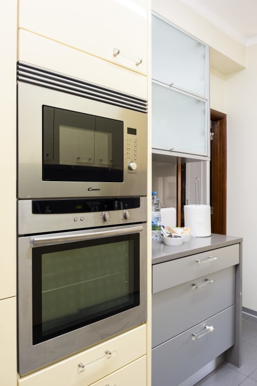 Cozinha moderna com micro-ondas e forno Candy em aço inoxidável no Apartamento Encantador RH, Barcelos