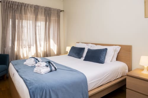 Quarto brilhante nos RH Charming Apartments em Barcelos com cama king, detalhes azuis e vista para a cidade