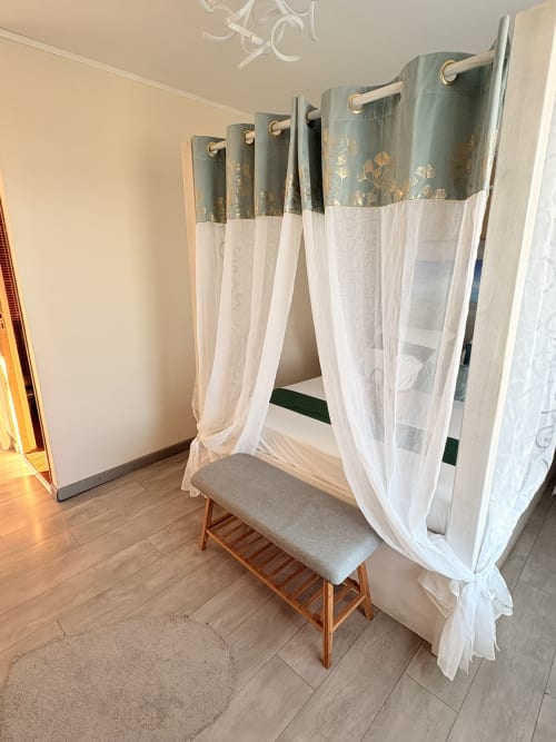 Lit à baldaquin élégant aux voilages blancs diaphanes dans une chambre supérieure à l'Hôtel le soleil couchant, St Pierre, Réunion