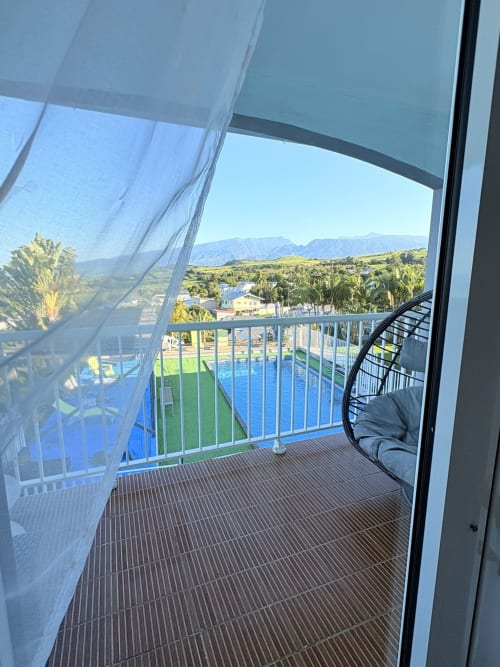 Vue depuis le balcon de l'Hôtel le soleil couchant à Saint-Pierre, La Réunion : piscine, jardins, montagnes et panorama sur la mer