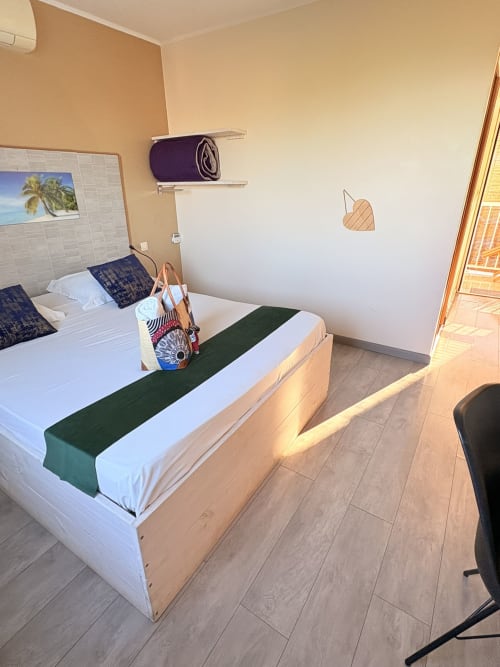 Grand lit avec chemin de table vert dans une chambre de l'Hôtel le soleil couchant, Saint-Pierre, Réunion