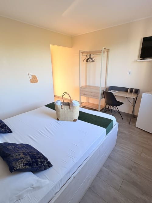 Chambre double moderne à l'Hôtel le soleil couchant, St Pierre, avec lit, bureau, armoire et vue sur le jardin