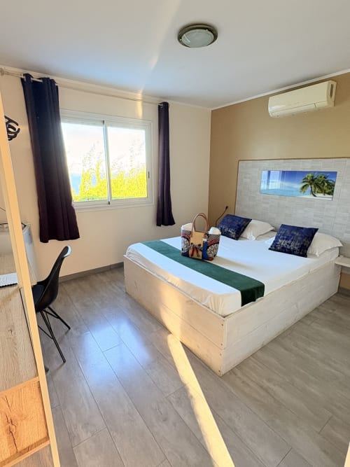 Chambre double C3 à l'Hôtel le Soleil Couchant à St Pierre avec lit queen, climatisation, TV et vue sur le jardin