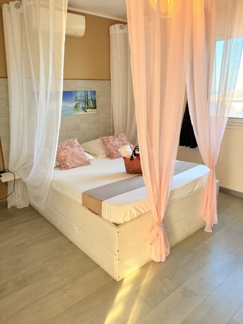 Lit à baldaquin luxueux aux voilages rose et blanc dans la chambre double C5 de l'Hôtel le soleil couchant, St Pierre, Réunion