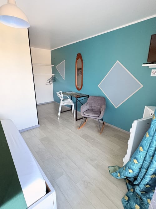 Chambre moderne à l'Hôtel le soleil couchant avec mur d'accent turquoise, sièges confortables et décor contemporain à St