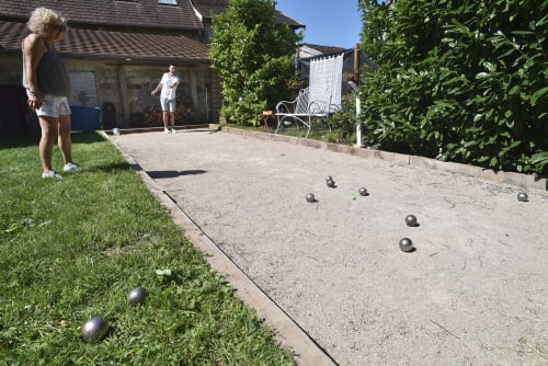 Ospiti che giocano a bocce nel cortile del Gîte le Douglas a Lavigny, Giura