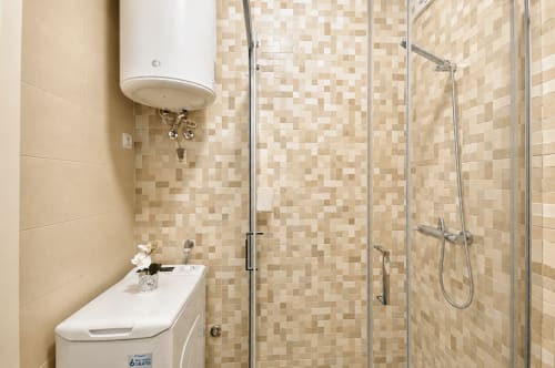 Banheiro moderno com chuveiro de azulejos em mosaico, box de vidro e aquecedor de água no RH Charming Apartments em Braga