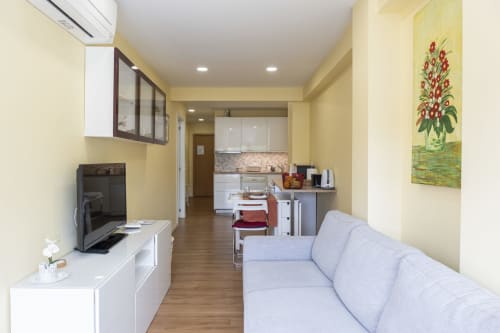 Moderno estúdio no RH Charming Apartments em Braga com sofá confortável, kitchenette e paredes amarelas