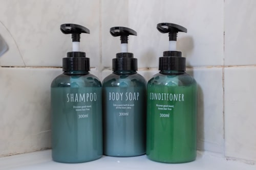 Tres botellas dispensadoras de champú, jabón corporal y acondicionador en el baño de Haus Holiday Homes, San Pedro del Pinatar