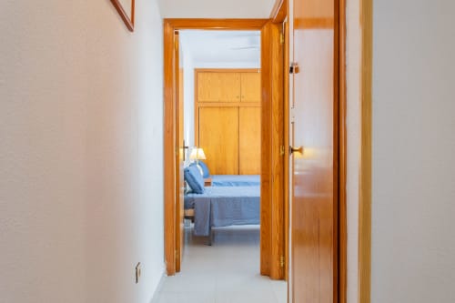Puerta de madera que conduce al dormitorio con cama azul en Haus Holiday Homes, San Pedro del Pinatar
