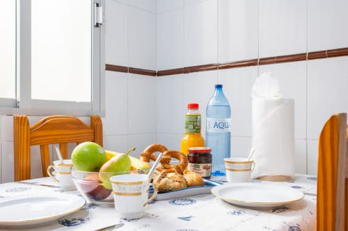 Mesa de desayuno en Casa Bibaziz, San Pedro del Pinatar, con frutas frescas, pastelería y agua