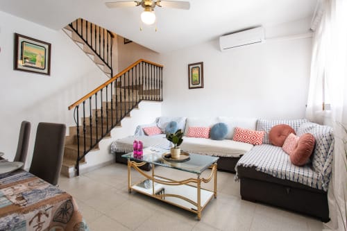 Luminosa sala de estar en Haus Holiday Homes, San Pedro del Pinatar, con escalera, sofá en L y mobiliario moderno