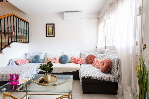 Luminoso salón de Casa Bibaziz en San Pedro del Pinatar con sofá en L, cojines coloridos y decoración moderna