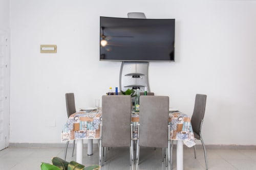 Comedor en Haus Holiday Homes con mesa, sillas y televisor de pared en San Pedro del Pinatar