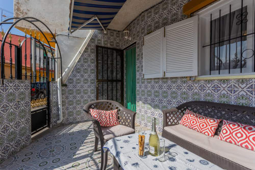 Zona de patio de Casa Bibaziz en San Pedro del Pinatar con paredes de azulejos, asientos y toldo rayado