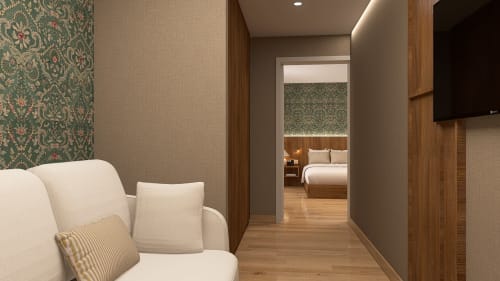 Entrada da suíte Feel Sintra com poltrona creme, papel de parede estampado, pisos em madeira e vista para quarto