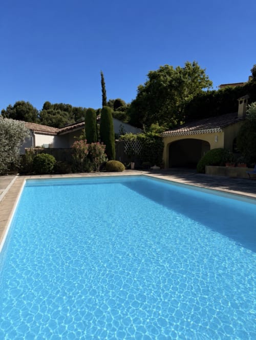 Piscine de la Conciergerie Maurin à Arles avec villa de style méditerranéen, cyprès et terrasse ensoleillée