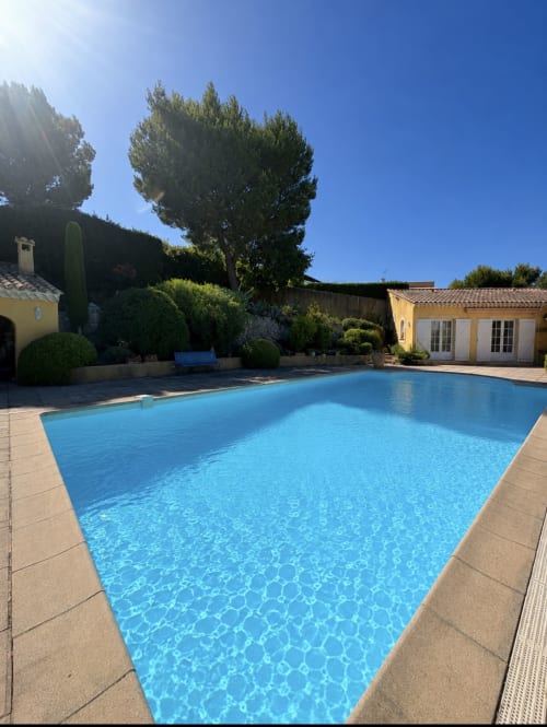 Piscine cristalline avec patio en terre cuite à la Conciergerie Maurin à Arles, entourée d'un aménagement paysager méditerranéen