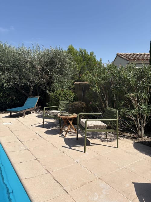 Terrasse ensoleillée de la Conciergerie Maurin à Arles avec vue sur la piscine, oliviers, chaises longues et mobilier de jardin