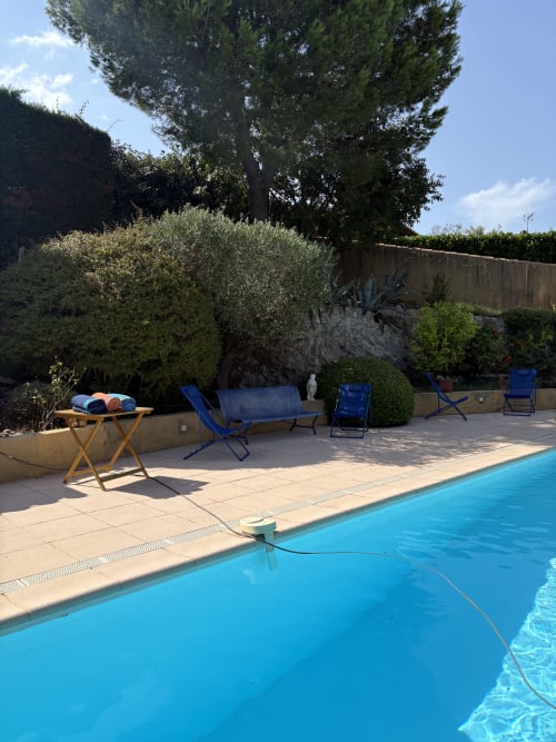 Piscine aux eaux cristallines avec chaises longues et terrasse à la Conciergerie Maurin, Arles, France