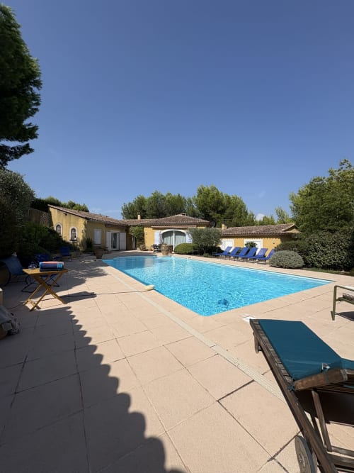 Piscine ensoleillée à la Conciergerie Maurin à Arles avec transats, villa en terre cuite et eau cristalline