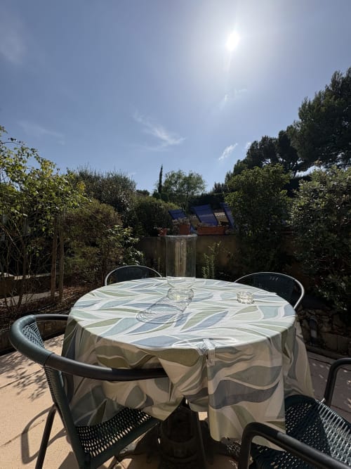 Table de salle à manger extérieure à la Conciergerie Maurin à Arles, entourée d'un jardin méditerranéen avec zone de piscine et transats