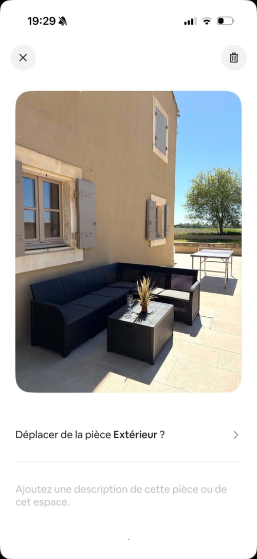 Terrasse extérieure du Mas en Camargue, Arles : mobilier de patio noir avec coussins bleu marine, petite table et paysage provençal