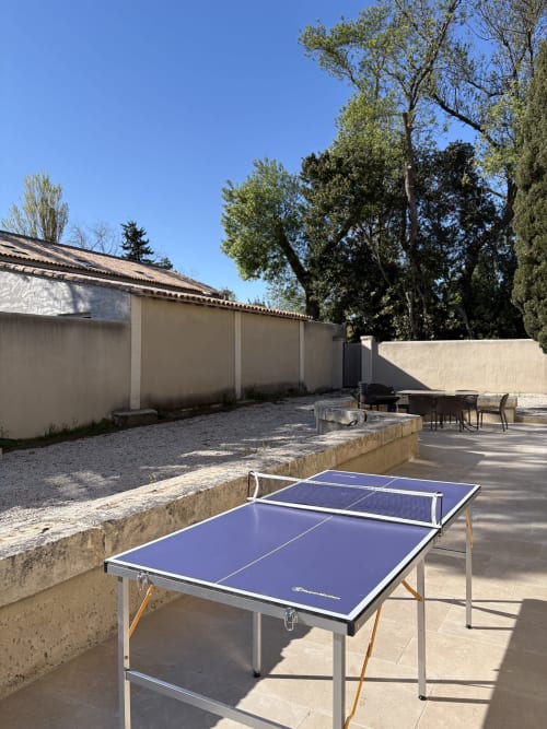 Patio extérieur avec tables de ping-pong à la Conciergerie Maurin à Arles, terrasse et vue sur le jardin