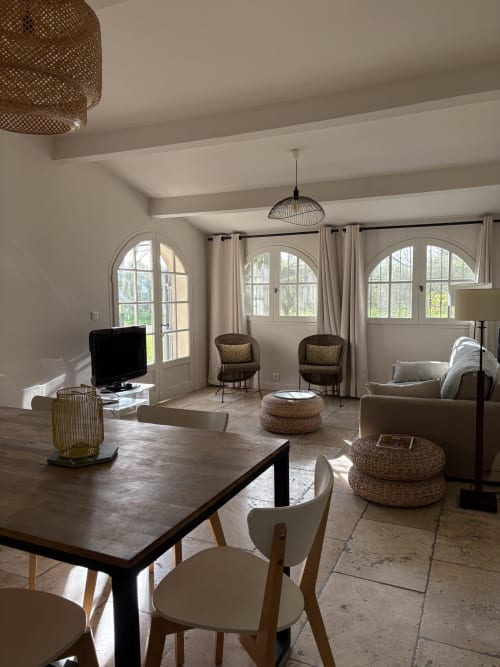 Spacieux séjour ouvert au Gite château de Pannis à Arles avec salle à manger, canapés, TV et vue sur le jardin