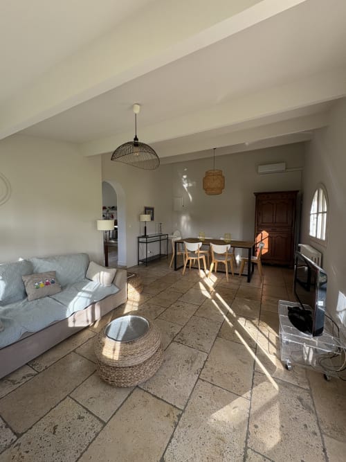 Spacieux séjour du Gîte château de Pannis à Arles avec table à manger, canapé et vue sur le jardin