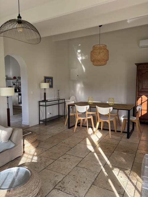 Salle à manger moderne du Gîte Château de Pannis à Arles avec table en bois, lumière naturelle et luminaires contemporains