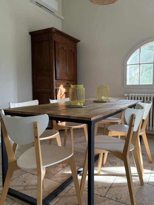 Salle à manger du Gîte Château de Pannis à Arles avec table en bois, chaises modernes et armoire d'époque